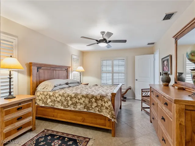 a bedroom with a bed a chandelier and a dresser