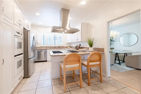 a kitchen with stainless steel appliances kitchen island granite countertop a table and chairs in it