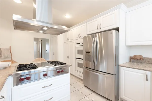 a kitchen with stainless steel appliances granite countertop a refrigerator sink and stove