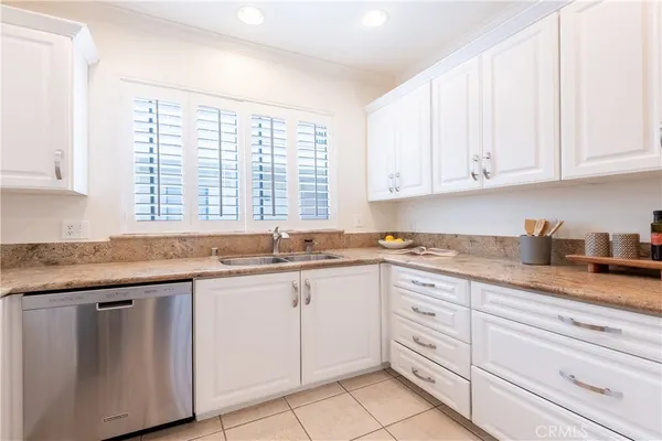 a kitchen with granite countertop white cabinets and white appliances