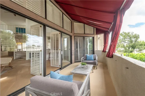 a balcony with furniture and a potted plant