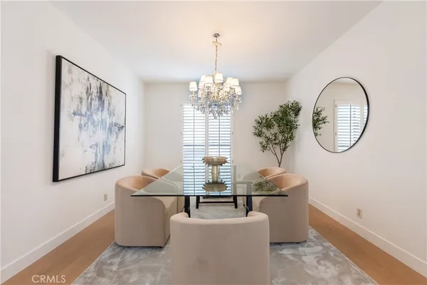 a living room with couches a table and paintings on the wall
