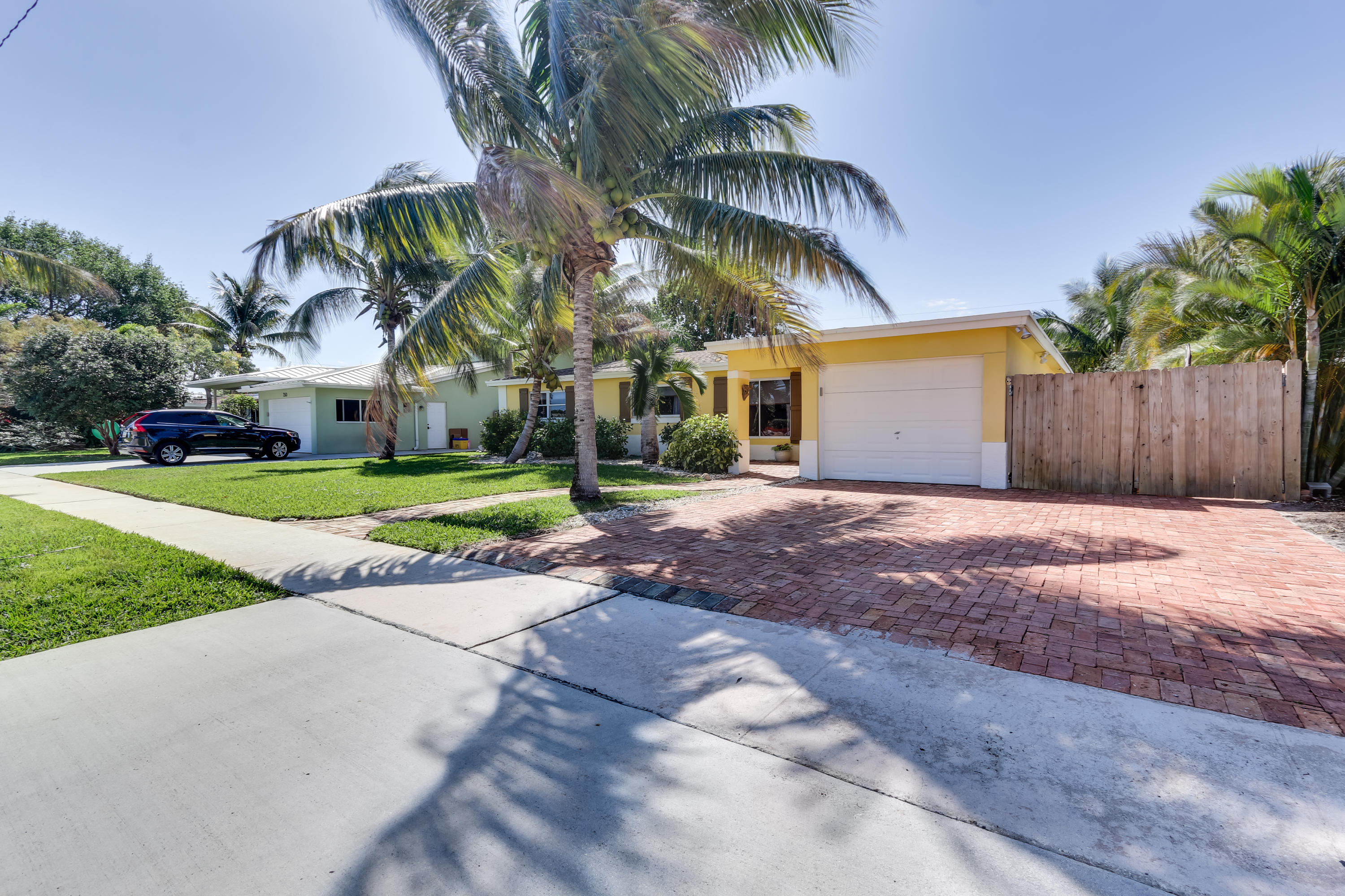 334 Northeast 28th Road Boca Raton, FL 33431 - Photo 3 of 32 a view of a white house with a big yard and palm trees