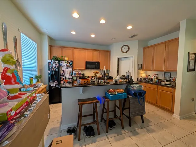 a room with stainless steel appliances kitchen island granite countertop furniture and a dining table