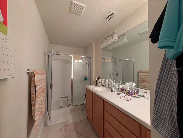 a bathroom with a double vanity sink mirror and shower