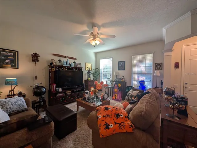 a living room with furniture a ceiling fan and a window