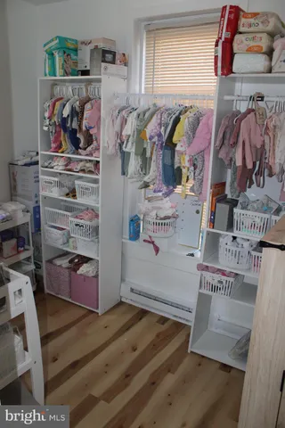 a view of walk in closet with clothes and shoes