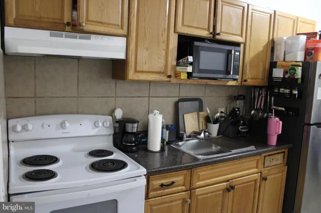 a kitchen with a sink a stove and cabinets