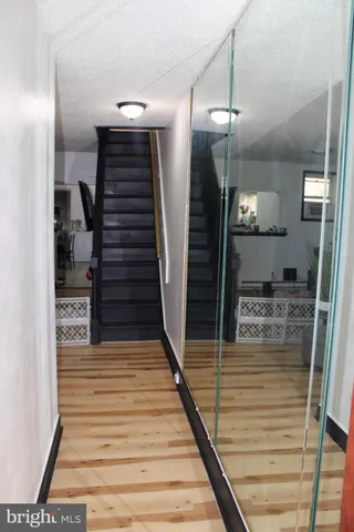 a view of a hallway with wooden floor and staircase