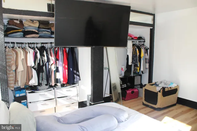 a view of walk in closet with clothes and shoes