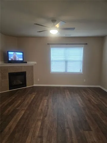 a view of empty room with wooden floor and a fireplace