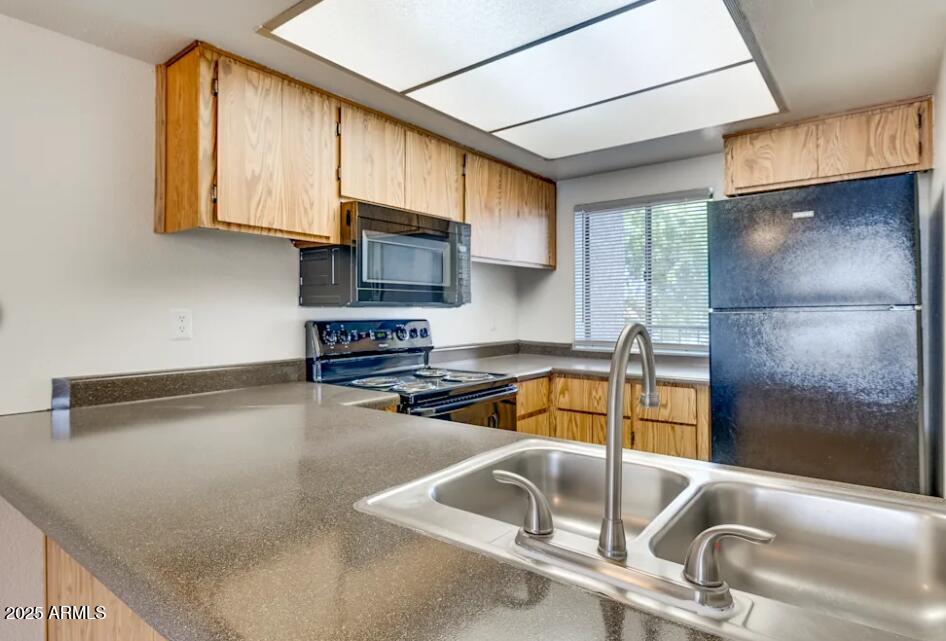 6505 East Osborn Road, Unit 21 Scottsdale, AZ 85251 - Photo 3 of 9 a kitchen with granite countertop a sink a counter top space cabinets and stainless steel appliances