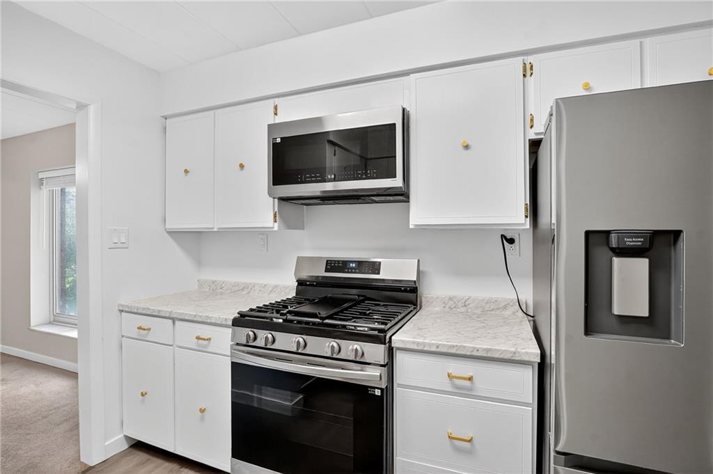 5 Bayard Road, Unit 500 Pittsburgh, PA 15213 - Photo 32 of 45 a kitchen with stainless steel appliances white cabinets and a stove top oven