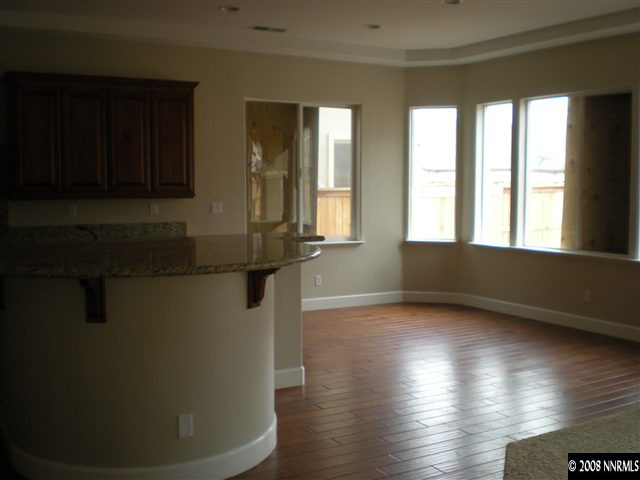 10010 Burghley Lane Reno, NV 89521 - Photo 5 of 9 a view of an empty room with wooden floor and a window