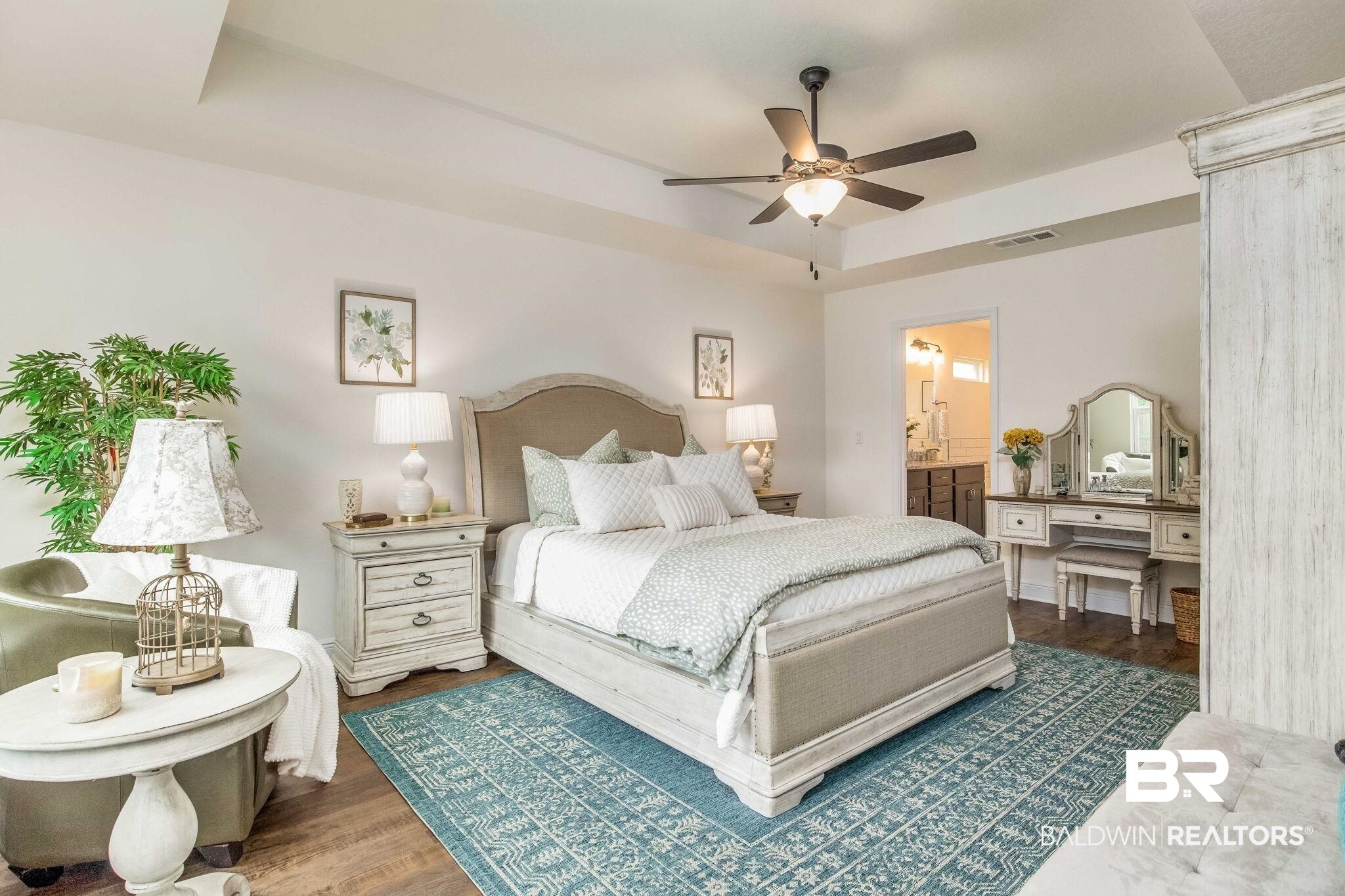 2222 Club House Drive Lillian, AL 36549 - Photo 11 of 49 Bedroom featuring wood finished floors, a tray ceiling, and a ceiling fan