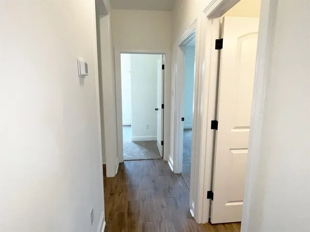 a view of a hallway with wooden floor