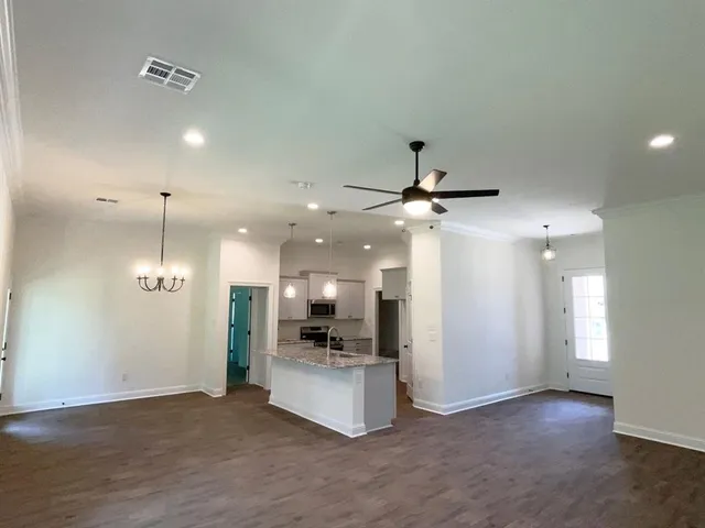 an open kitchen with a refrigerator and a microwave
