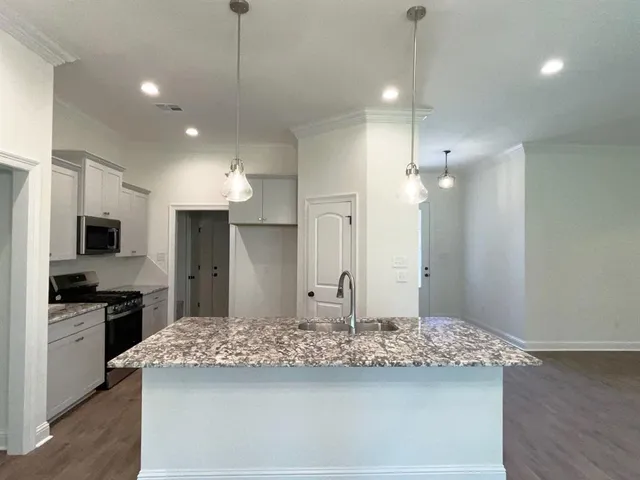 a kitchen with kitchen island a sink stainless steel appliances and cabinets