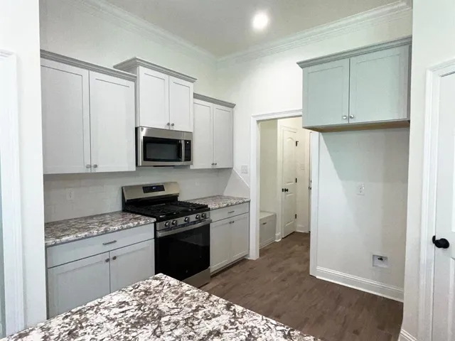 a kitchen with a refrigerator stove and white cabinets