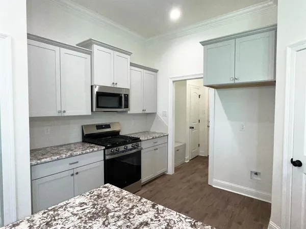 a kitchen with a refrigerator stove and white cabinets