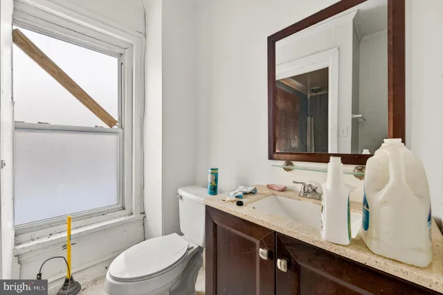 a bathroom with a sink vanity mirror and toilet