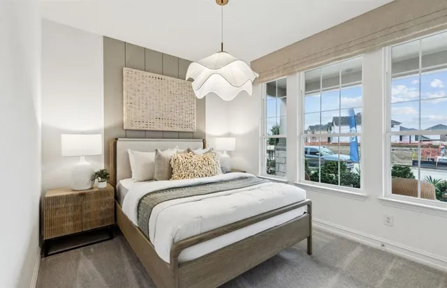 a bedroom with a large bed and a chandelier