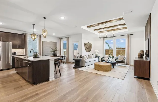 a living room with stainless steel appliances kitchen island granite countertop furniture a large window and a kitchen view