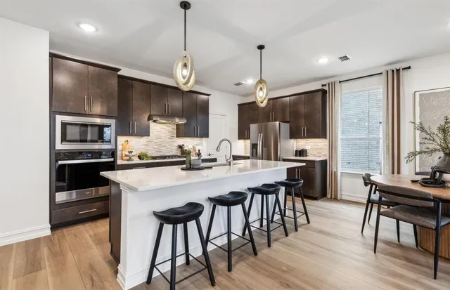 a kitchen with stainless steel appliances kitchen island a chandelier and refrigerator