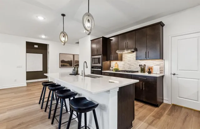 a kitchen with a table chairs sink and cabinets