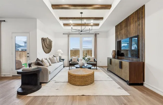 a living room with furniture a chandelier and a large window