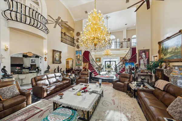 a living room with patio furniture and a chandelier