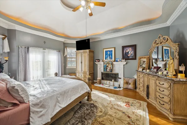 a spacious bedroom with a bed a dresser and flat screen tv