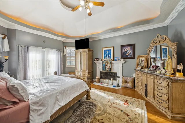 a spacious bedroom with a bed a dresser and flat screen tv