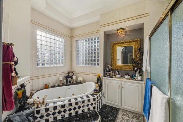 a bathroom with a tub sink and mirror