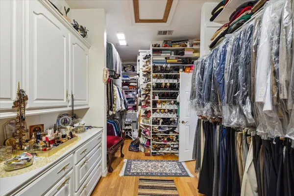 a view of walk in closet with clothes and shoes