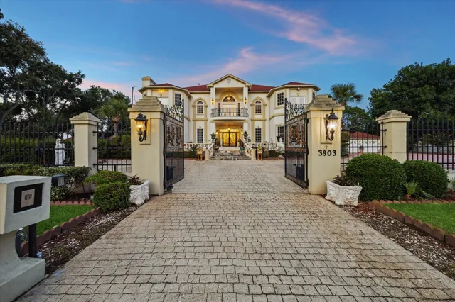 a view of a white house with a yard and potted plants