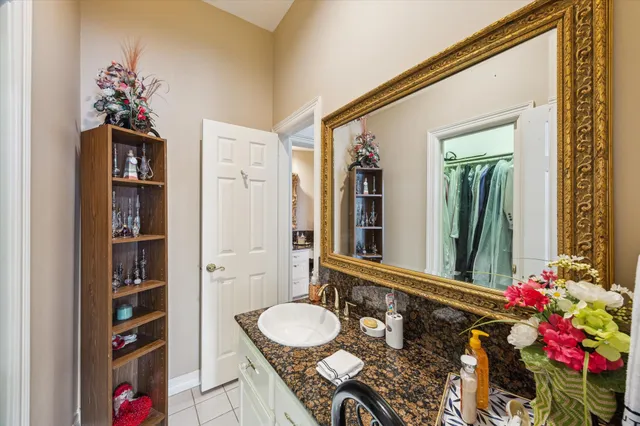 a bathroom with a granite countertop sink a mirror and a shower