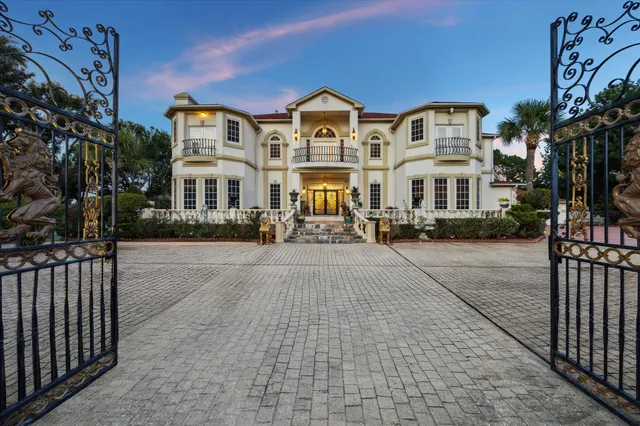 a front view of a building with cars parked on road