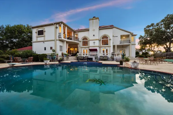 a front view of a house with garden and lake view