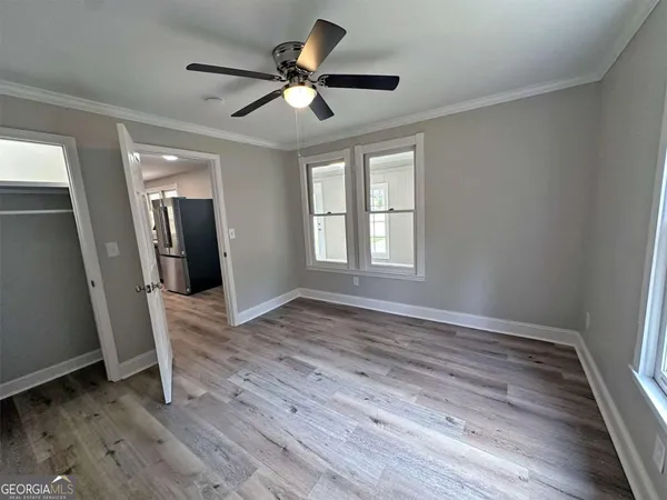 an empty room with wooden floor and windows
