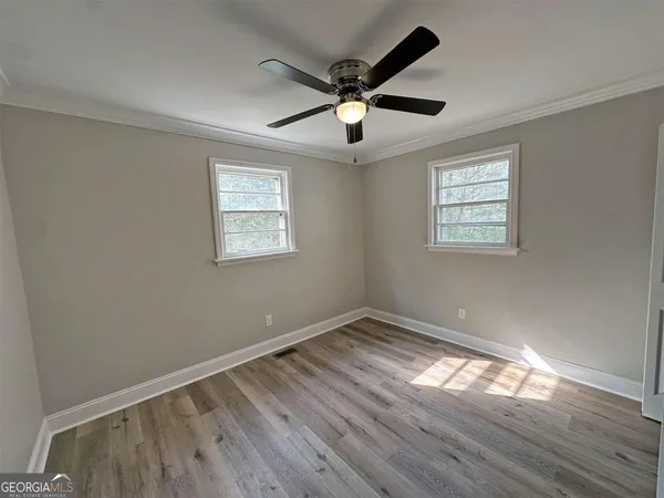 a view of empty room with wooden floor