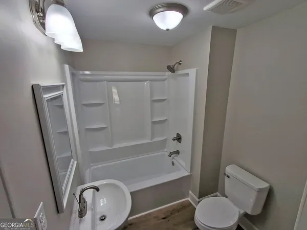 a bathroom with a shower a toilet and a sink