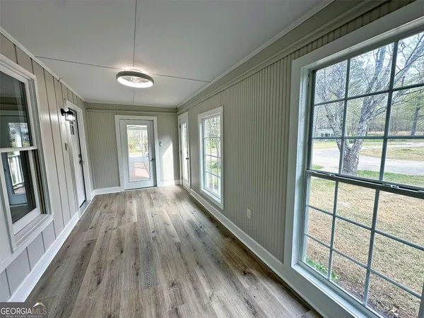 a view of hallway with a large window and wooden floor