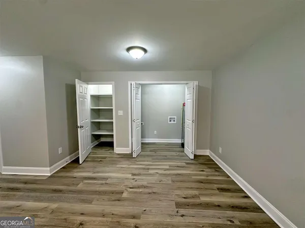 a view of empty room with wooden floor
