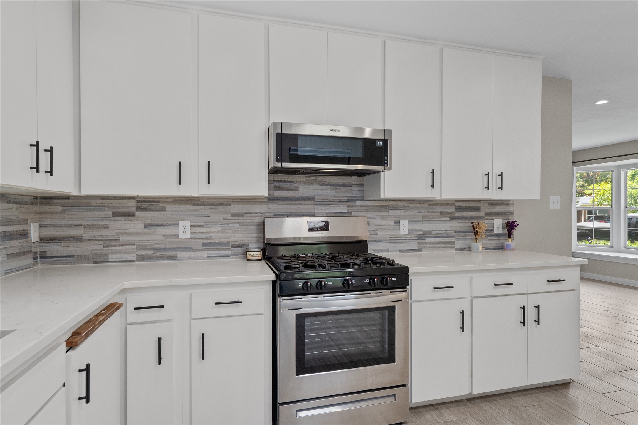 7707 Robalo Road Austin, TX 78757 - Photo 11 of 33 A well-appointed kitchen features sleek white cabinetry and a full suite of stainless steel appliances.