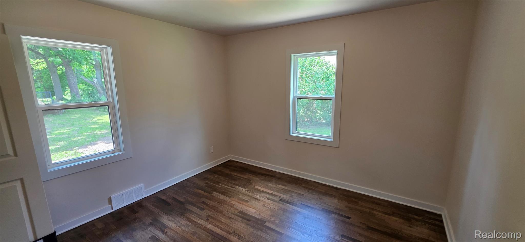9205 Neff Road Clio, MI 48420 - Photo 12 of 35 Room featuring wood-finish flooring, neutral wall tones, and white trim