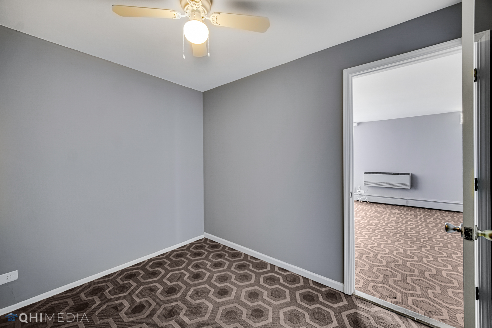 5740 North Sheridan Road, Unit 12C Chicago, IL 60660 - Photo 17 of 19 an empty room with a chandelier fan and wooden floor