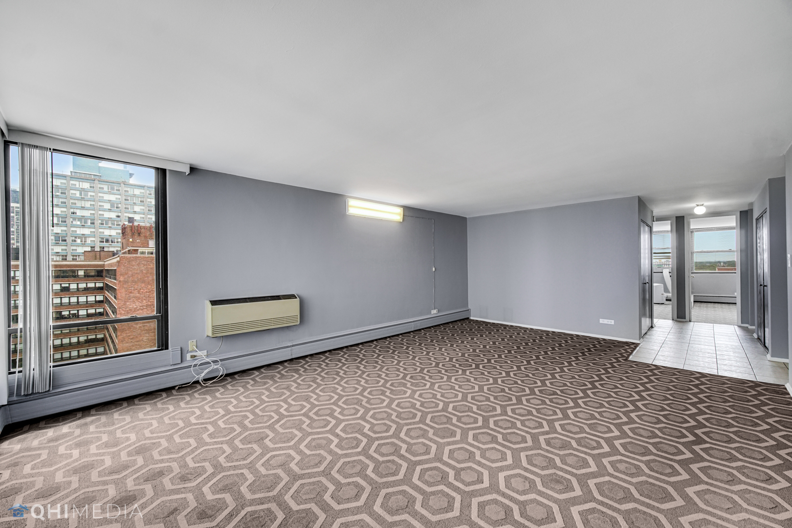 5740 North Sheridan Road, Unit 12C Chicago, IL 60660 - Photo 3 of 19 wooden floor in an empty room with a window