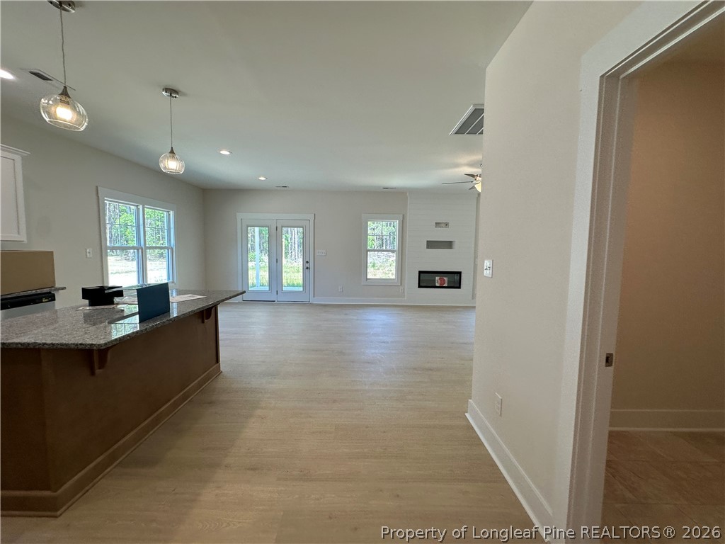 2908 Calloway Road Raeford, NC 28376 - Photo 7 of 25 a living room with stainless steel appliances kitchen island granite countertop a refrigerator a sink a stove and a window