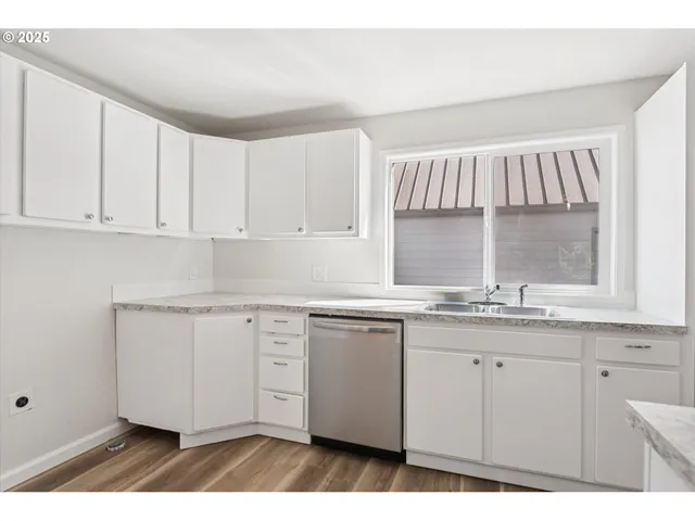 a kitchen with granite countertop a sink stainless steel appliances and cabinets